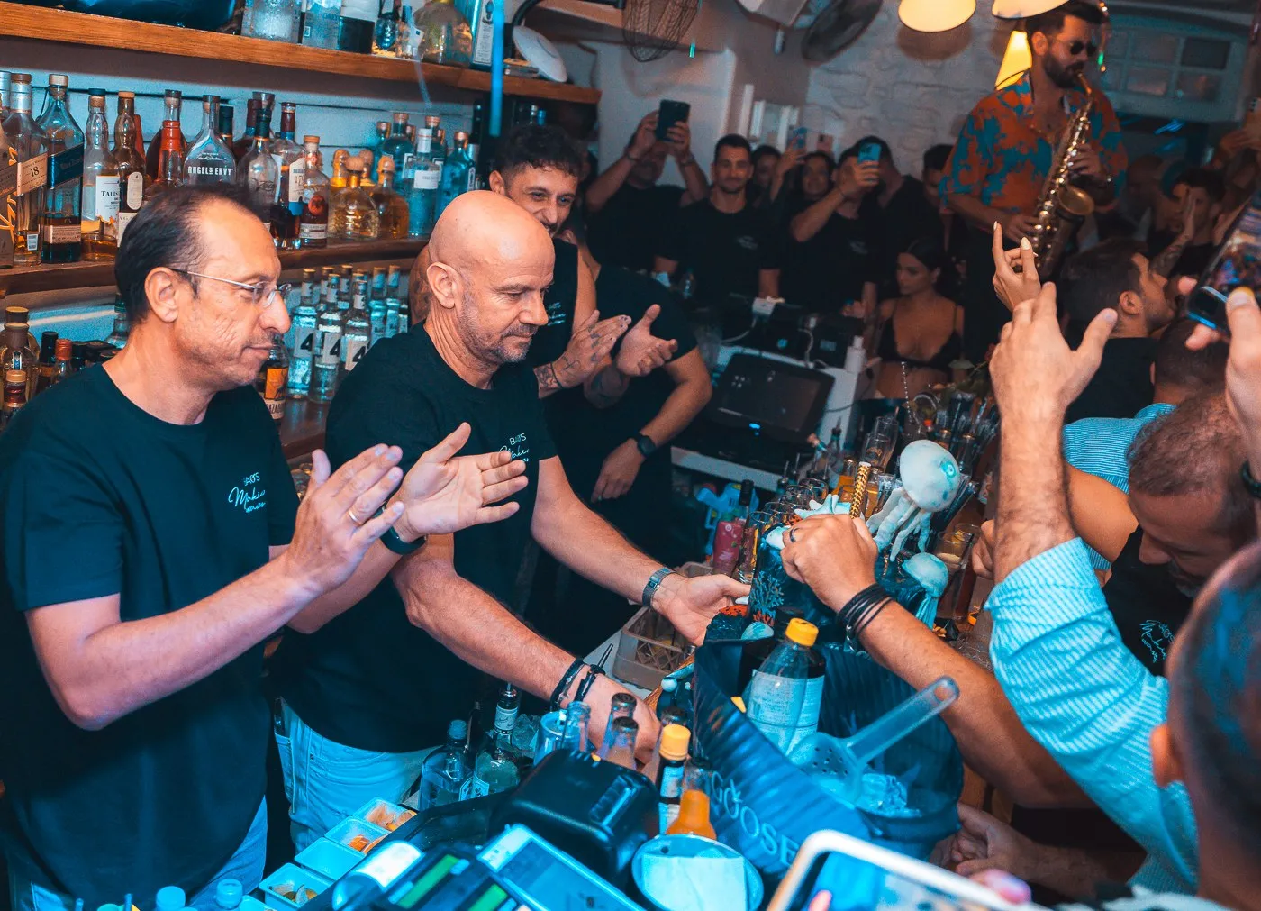 The crew and guests celebrating together behind the bar at BAO'S