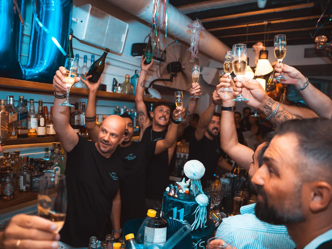 Champagne glasses raised together over the bar at BAO'S