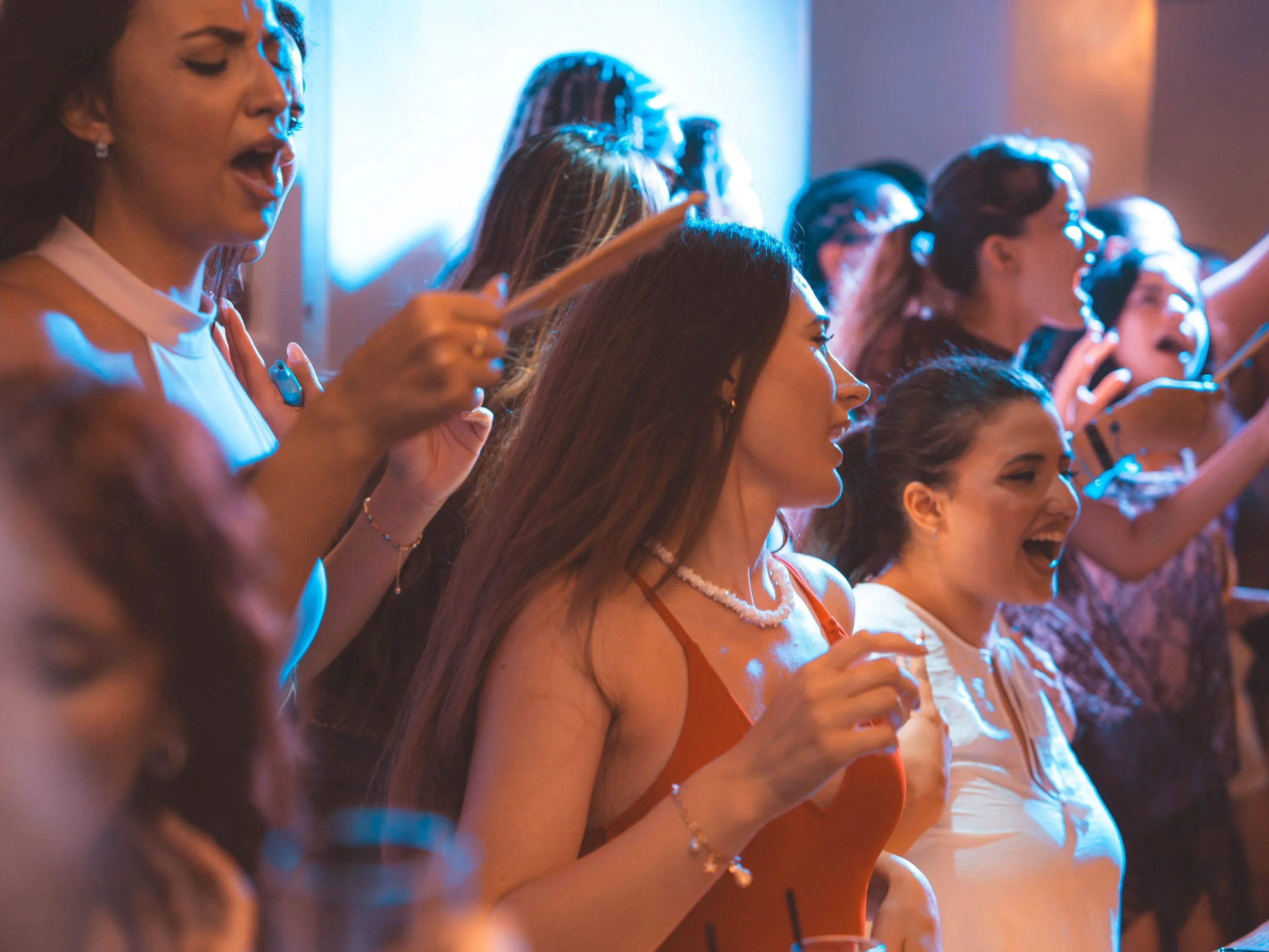 Guests raising their drinks together in a packed room at BAO'S