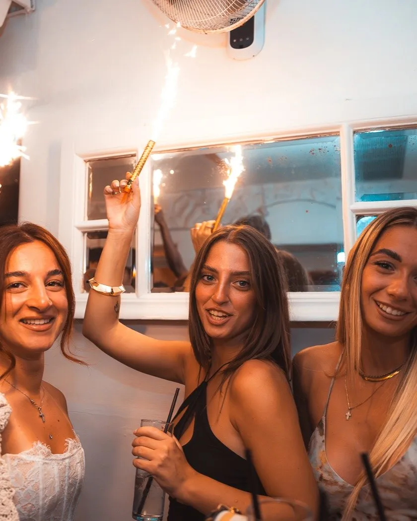 Three guests at BAO'S raising a sparkler between them