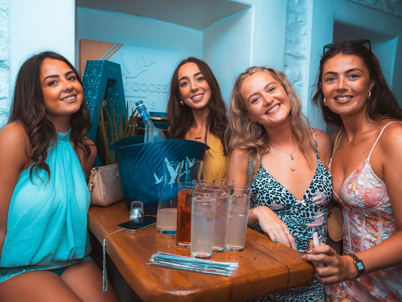Four guests around a table at BAO'S with an ice bucket and tall drinks