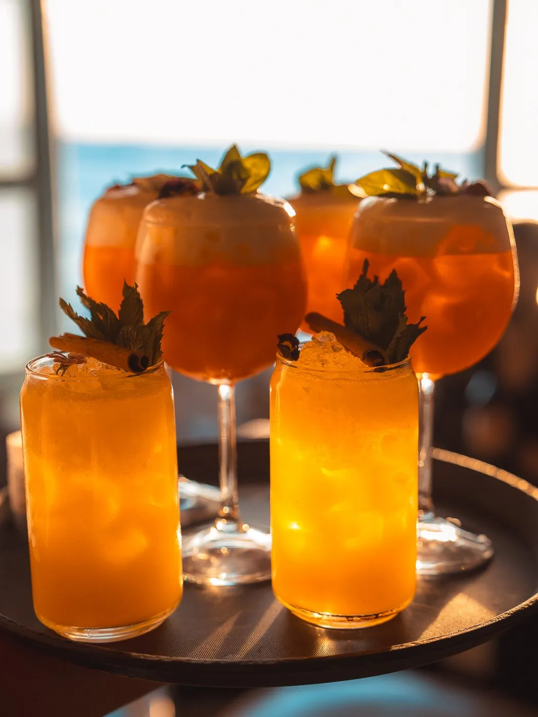 A BAO'S cocktail on the ledge beneath a macramé parasol, the houses of Little Venice behind