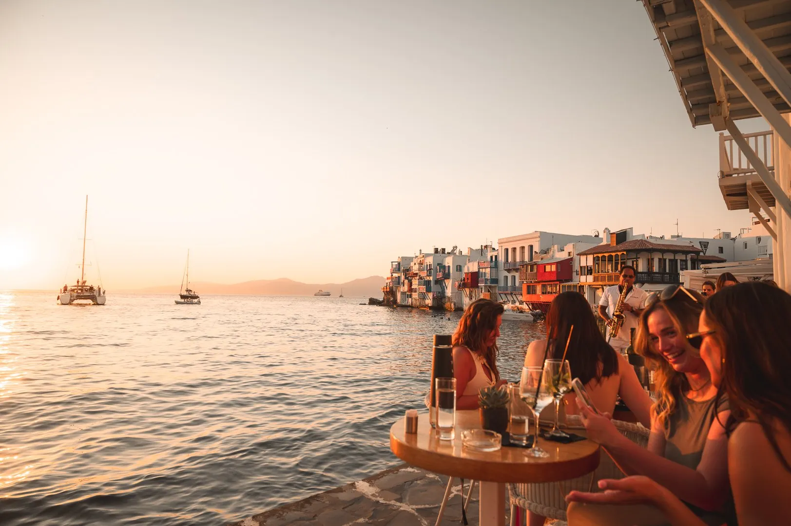 Guests at a table on the water at BAO'S as the sun sets over Little Venice