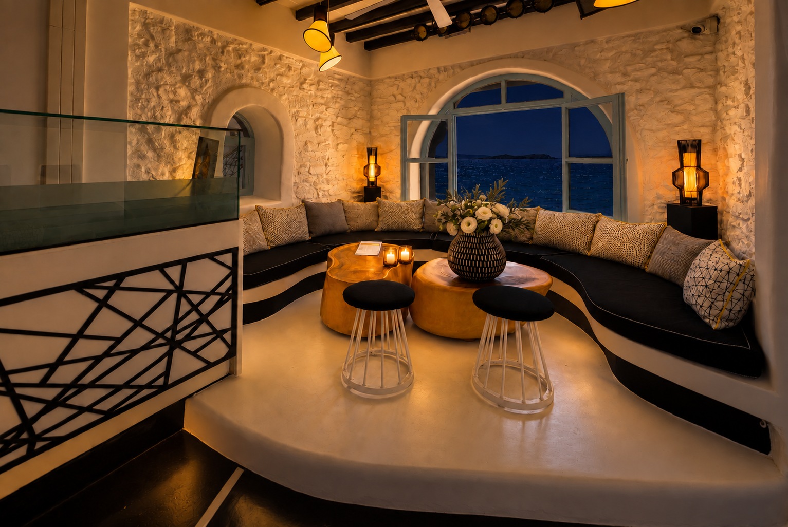 The Rotonda Table seen from the walkway railing at night, candlelit on its platform, the window dark behind